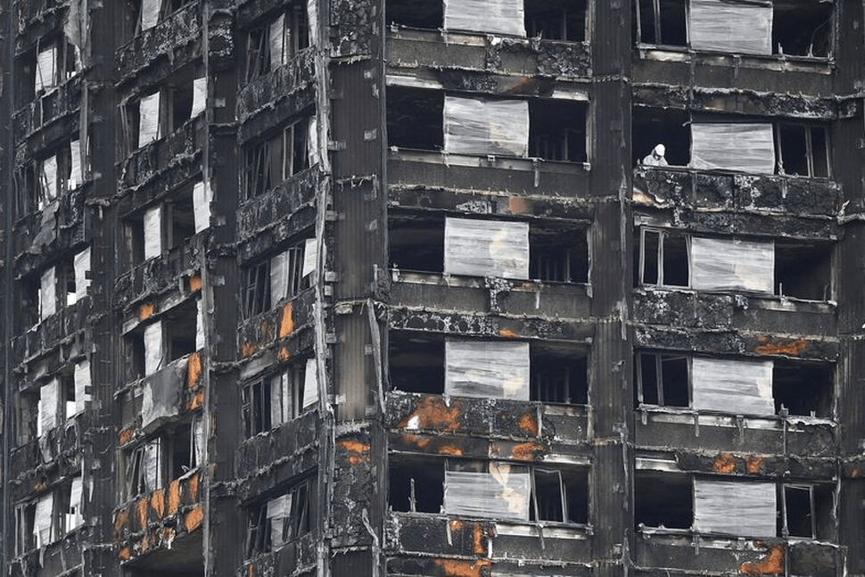 FILE PHOTO: An official works in the burnt out remains of the Grenfell Tower residential building in London, Britain, September 20, 2017. REUTERS/Toby Melville/File Photo