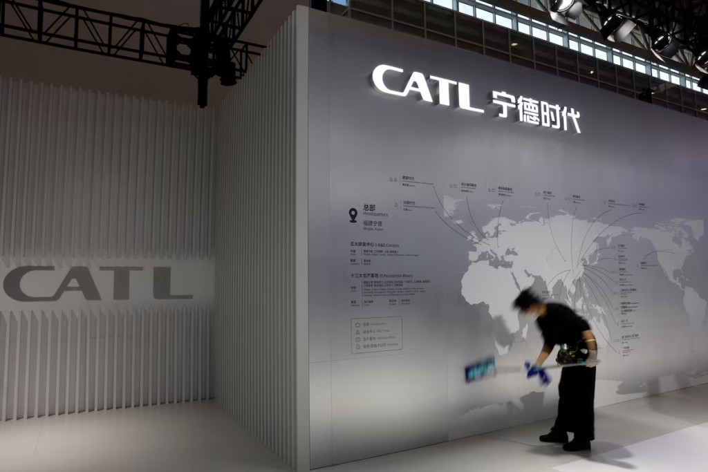 A staff member cleans a display showing the locations of battery maker CATL's production bases. Reuters