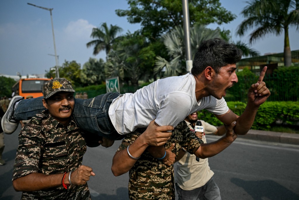 Security personnel detain a student activist during a protest demanding the resignation of the nation's Chief Election Commissioner Gyanesh Kumar over alleged voter roll irregularities linked to the "special intensive revision" (SIR), in New Delhi on October 13, 2026. (Photo by Arun SANKAR / AFP)