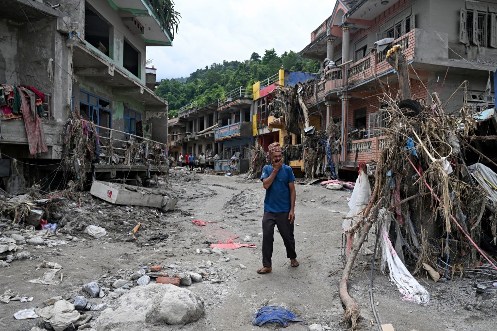 A man walks past damaged houses following flash floods at Devighat in Nepal's Nuwakot district on August 31, 2026. (AFP)