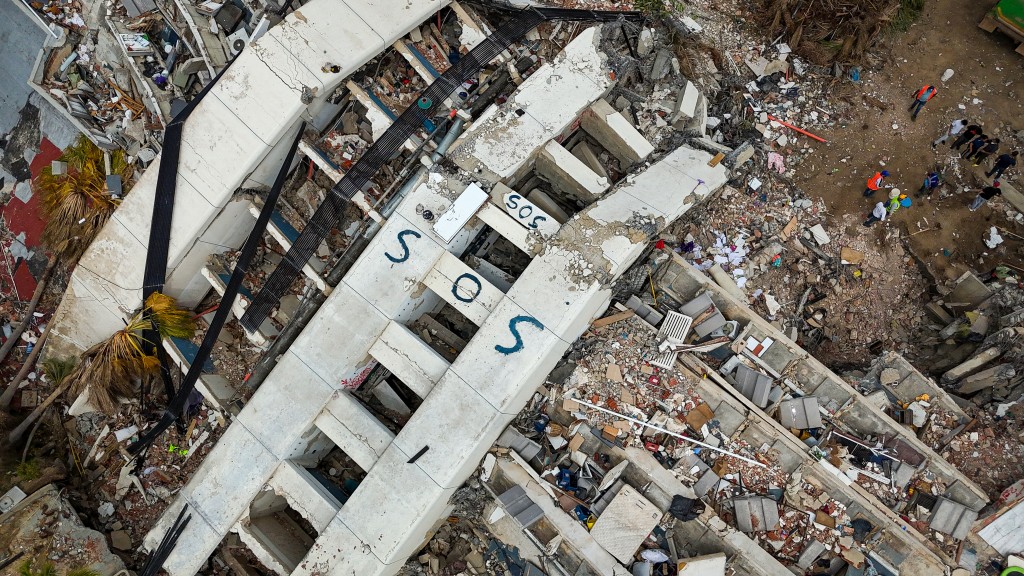 Photo by MIGUEL MEDINA / POOL / AFP  This aerial view taken on July 2, 2026 in Caraballeda in the state of La Guaira shows collapsed buildings following the June 24 twin earthquakes.