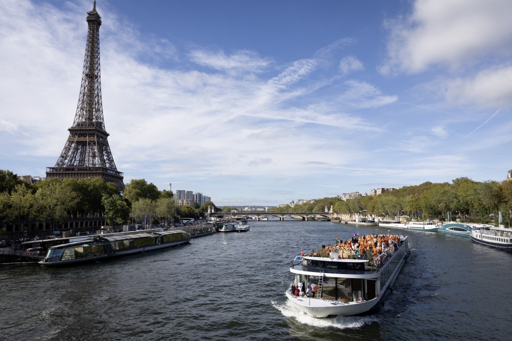 Members of the Bochasanwasi Akshar Purushottam Swaminarayan Sanstha (BAPS) Hindu community pass the Eiffel tower as they take part in a ceremonial river parade on the river Seine in Paris on September 3, 2026, as part of a series of religious celebrations and rituals. (Photo by Kenzo TRIBOUILLARD / AFP)
