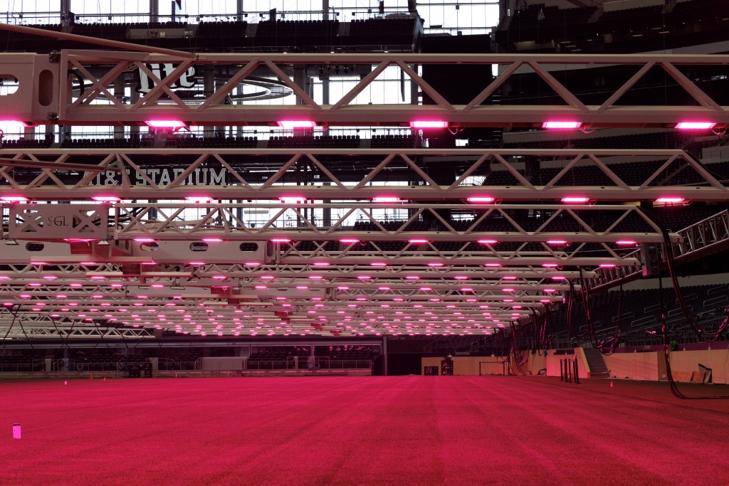 Photo by MARK FELIX / AFP  Pink lights illuminate newly laid grass on the pitch inside AT&T Stadium, which will be called "Dallas Stadium" during the duration of the tournament, in Arlington, Texas on May 18, 2026.