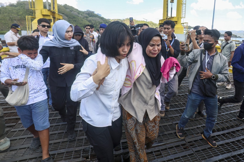 Photo by STR / AFP  A distressed woman is supported by a rescue team member upon arriving at Lembar port in West Lombok on August 12, 2026.