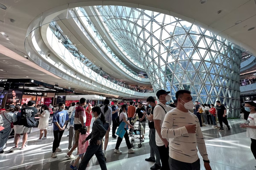 People wearing face masks following the coronavirus disease (COVID-19) outbreak walk in the Sanya International Duty-Free shopping complex in Sanya, Hainan province, China January 25, 2023. REUTERS