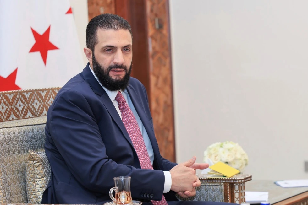 In this photo released by the Syrian official news agency SANA, Syria’s interim President Ahmad al-Sharaa receives the final version of the provisional electoral system for the People’s Assembly, in Damascus, Syria, Sunday, July 27, 2025. (SANA via AP, file)