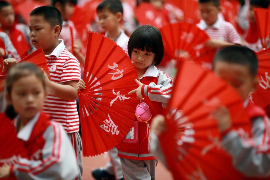  Children perform a Kung Fu Fan dance while carrying plastic eggs during the "egg protection" activity designed by the school for its students to understand motherhood in Guilin, Guangxi autonomous region, China May 11, 2018. REUTERS/Stringer