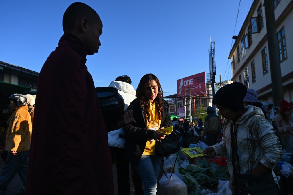 Photo by SAI AUNG MAIN / AFP  This photo taken on December 9, 2025 shows People's Party candidate Khine Thin Kyi talking to people at a market as she campaigns ahead of Myanmar's general election in Pyin Oo Lwin in Myanmar’s Mandalay Region.