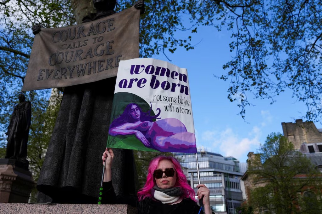 A woman holds a sign at Parliament Square in London, Britain, April 16, 2025. REUTERS/Maja Smiejkowska