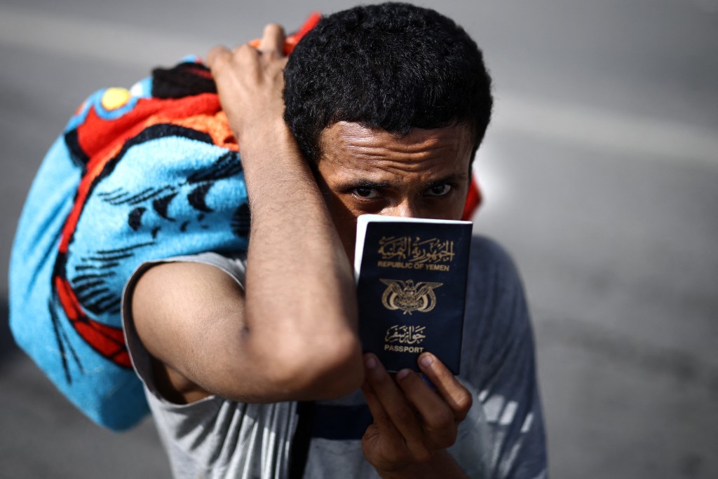 A migrant shows his passport while being escorted to the Ceuta-Morocco border in the Spanish North African enclave of Ceuta on August 1, 2026. (AFP)