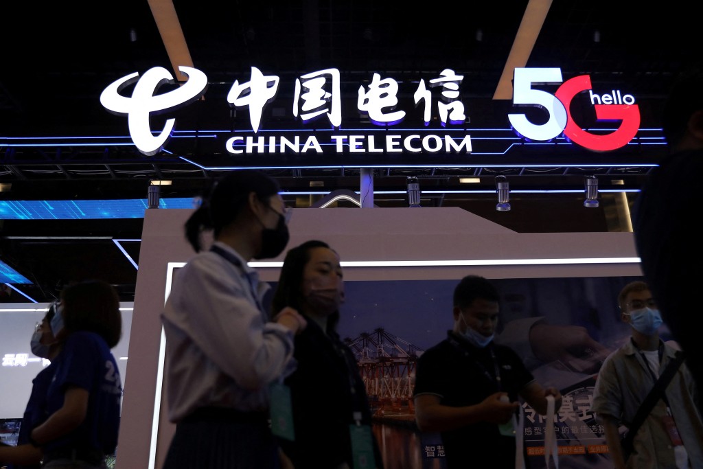 People are seen at a China Telecom booth at an exhibition during China Internet Conference in Beijing, China, July 13, 2021. REUTERS/Tingshu Wang/File Photo
