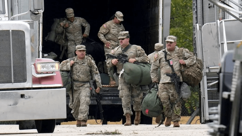 Military personnel in uniforms with the Texas National Guard patch are seen at the US Army Reserve Center in Elwood, Illinois, on Tuesday. - Erin Hooley/AP