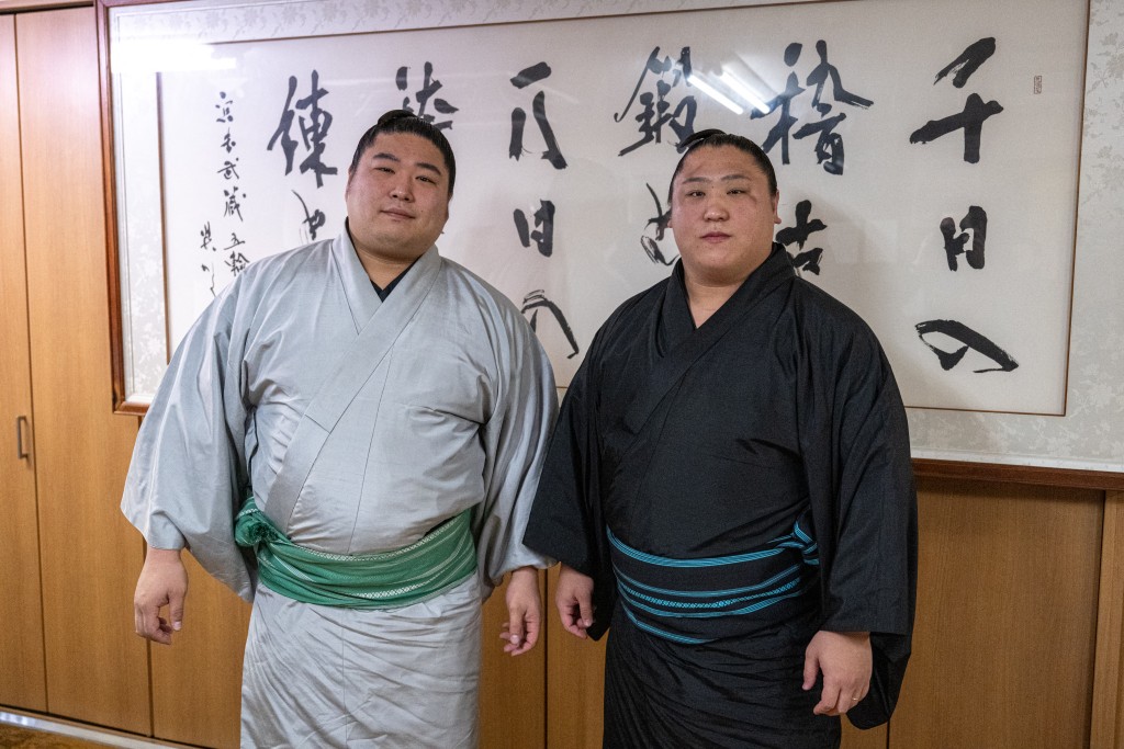 Photo by MATHIAS CENA / AFP  This picture taken on January 7, 2026 shows the first-division wrestlers and brothers Wakamotoharu (L) and Wakatakakage posing after morning practice at the Arashio sumo stable in Tokyo This picture taken on January 7, 2026.