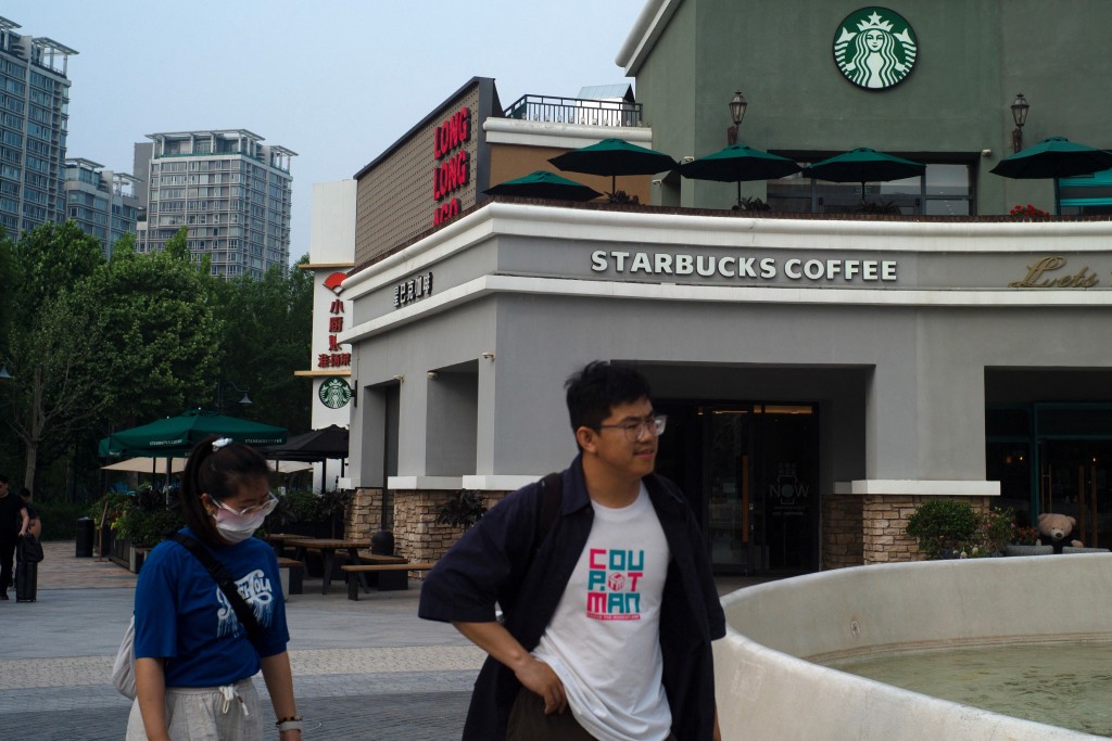 People walk past a Starbucks coffee shop in Beijing, China, May 22, 2024. REUTERS/Tingshu Wang