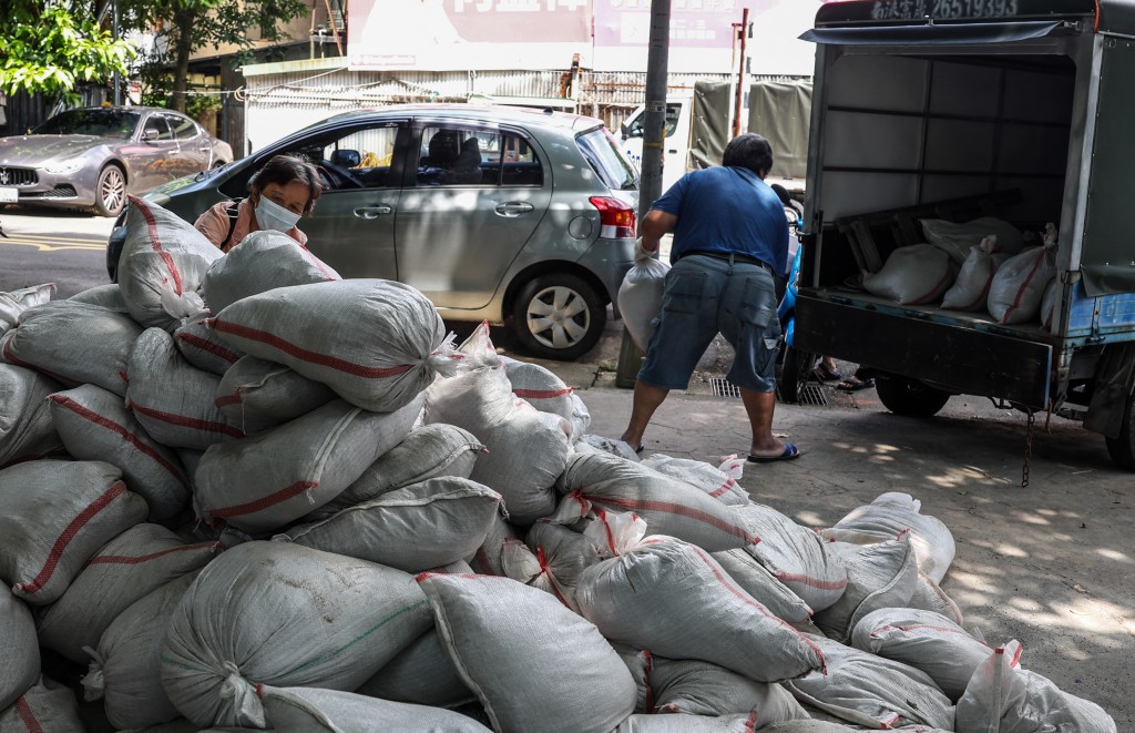 People load sandbags onto a truck as preparations are made ahead of the arrival of Typhoon Bavi, in Taipei on July 9, 2026 (Photo by I-Hwa Cheng / AFP)