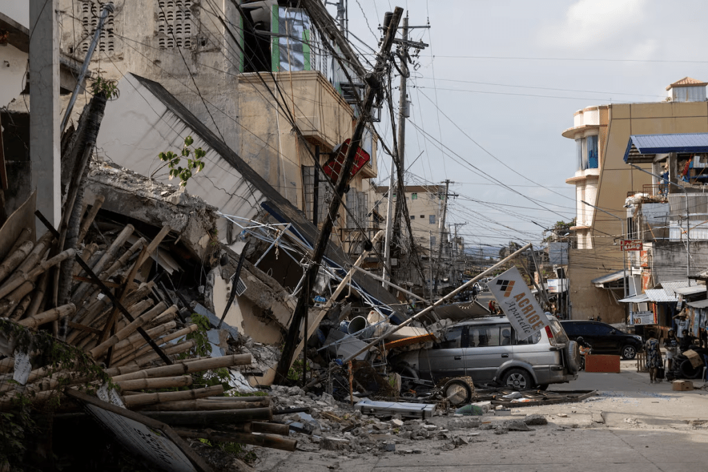 A vehicle partially buried under rubble amid destruction caused by the magnitude 6.9 quake in Bogo, Cebu, Philippines. REUTERS/Eloisa Lopez 