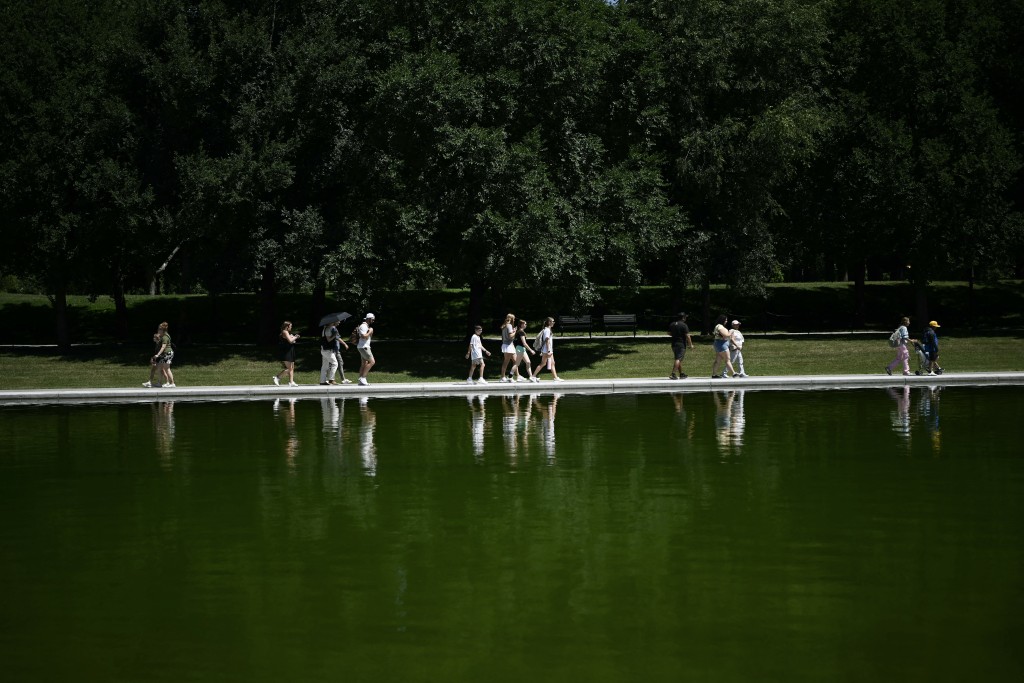 Photo by BRENDAN SMIALOWSKI / AFP  Visitors walk near the Lincoln Memorial Reflecting Pool following the completion of recent renovations in Washington, DC, on June 16, 2026.