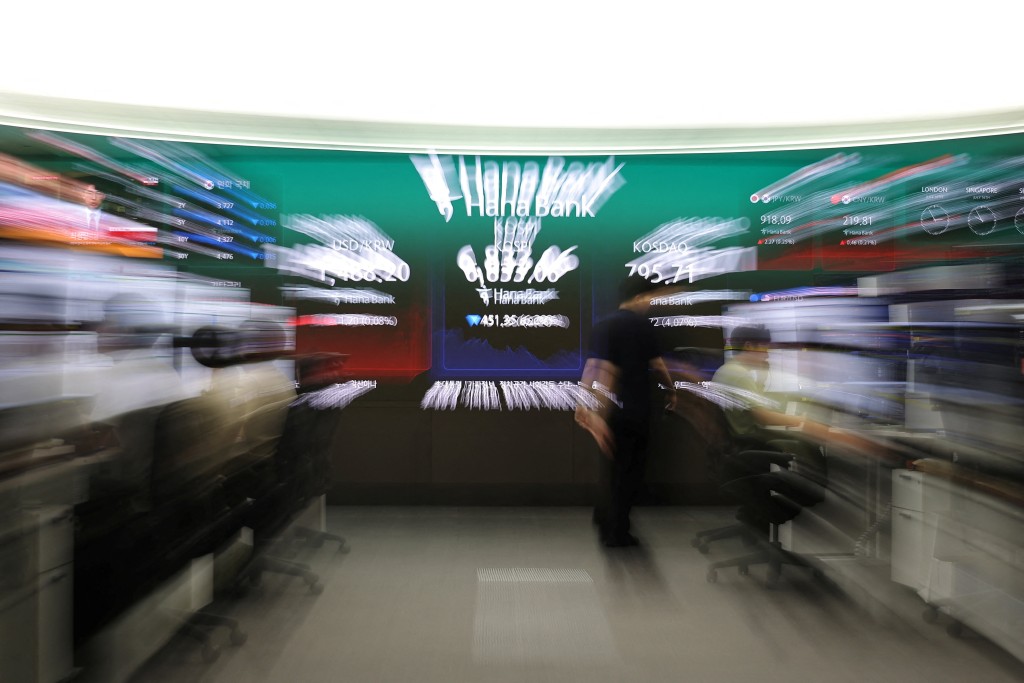 A currency dealer walks in front of an electronic board displaying the exchange rate between the U.S. dollar and South Korean won, the Korea Composite Stock Price Index (KOSPI) and the Korea Securities Dealers Automated Quotations (KOSDAQ) at the dealing room of a bank in Seoul, South Korea, July 16, 2026. REUTERS