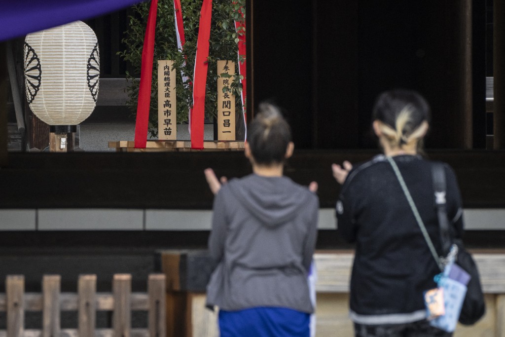 A wooden plaque bearing the name of Japan’s Prime Minister Sanae Takaichi (L) is seen beside a “masakaki” tree that she sent as an offering to the Yasukuni Shrine on the first day of the Spring Festival, in Tokyo on April 21, 2026. (Photo by Yuichi YAMAZAKI / AFP)