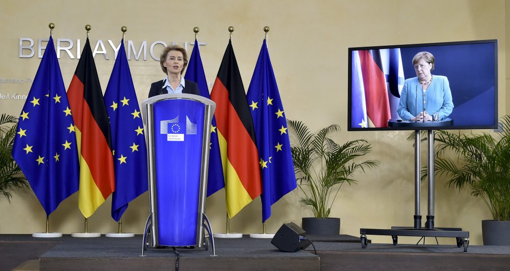 President of the European Commission Ursula von der Leyen, left rear, addresses a joint press conference with German Chancellor Angela Merkel, attending by video conference on screen right, at the start of the six month German Presidency of the EU. President of the European Commission Ursula von der Leyen, left rear, addresses a joint press conference with German Chancellor Angela Merkel, attending by video conference on screen right, at the start of the six month German Presidency of the EU.