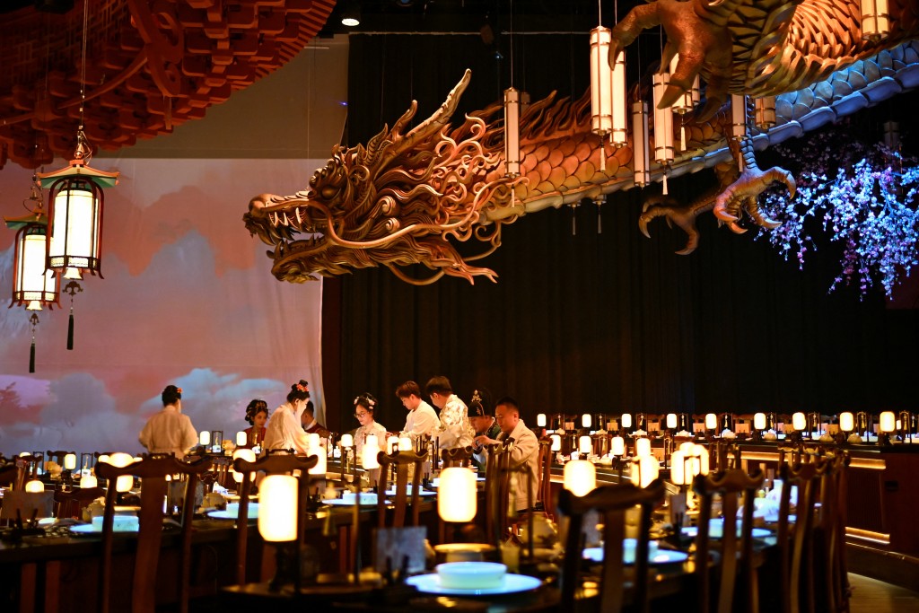 Photo by WANG ZHAO / AFP  This picture taken on November 5, 2025 shows people in traditional Chinese clothes having their meals at a theatrical restaurant in Beijing.