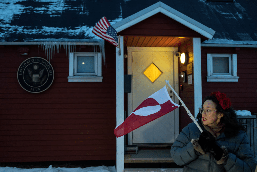  A person displays a Greenlandic flag, as people protest in front of the U.S. consulate in Nuuk, Greenland, January 22, 2026. REUTERS/Marko Djurica 