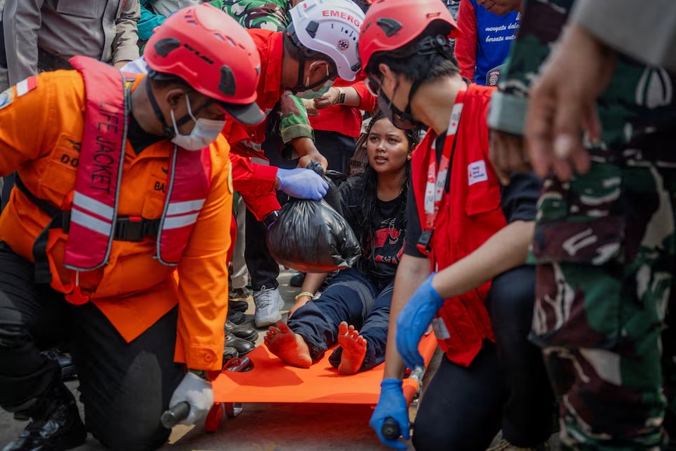 A passenger of the Virgo Transport 8 ferry that capsized in the Java Sea while sailing from Surabaya in East Java to Banjarmasin in South Kalimantan, sits on a stretcher upon arrival at Trisakti port in Banjarmasin, South Kalimantan province, Indonesia, September 15, 2026. REUTERS/Stringer