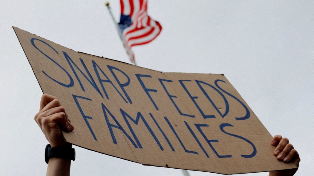 A man holds a sign during 'A Rally for SNAP' on the steps of the Massachusetts Statehouse in Boston.  REUTERS