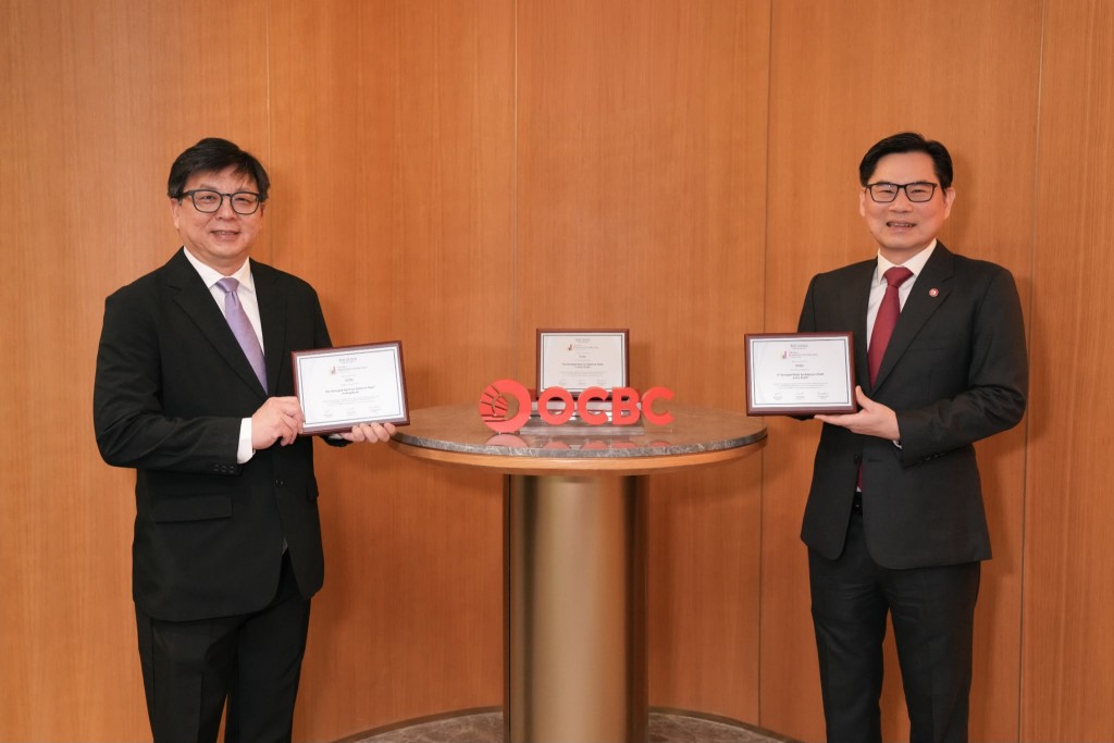 Foo Boon Ping, president and managing editor, TAB Global, presenting the award to Tan Teck Long. OCBC