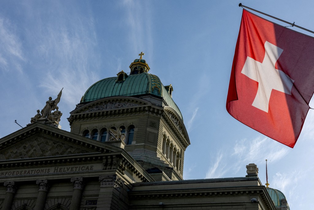 A Swiss flag is seen on the Swiss Parliament building (Bundeshaus) in Bern, Switzerland, November 6, 2024. REUTERS/Denis Balibouse//File Photo