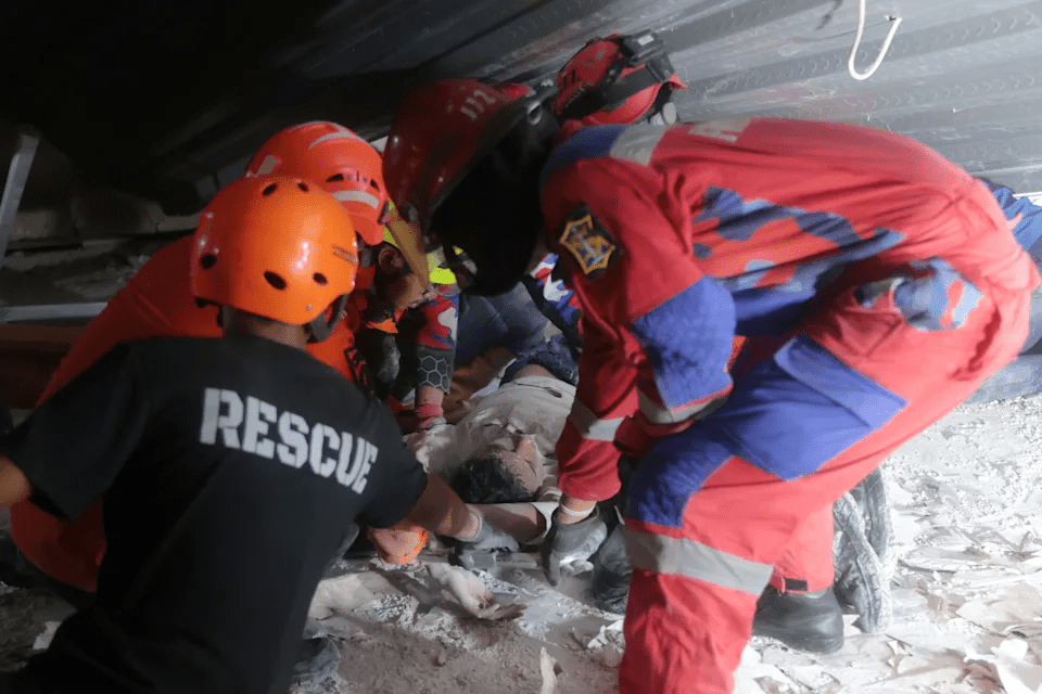 Rescuers pull out a survivor from a collapsed building at an Islamic boarding school in Sidoarjo, East Java, Indonesia, Monday, Sept. 29, 2025. (AP Photo/Trisnadi)