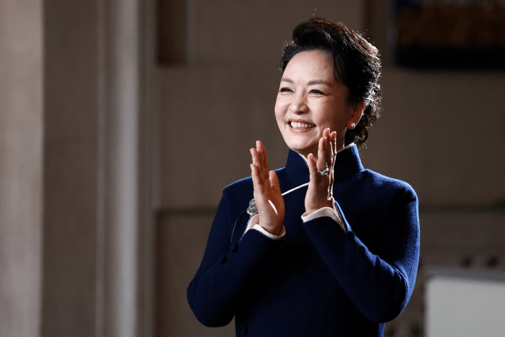 First lady of China Peng Liyuan reacts as children perform during a visit to the Smithsonian's National Museum Of Asian Art from Director of the museum Chase Robinson in Washington, D.C., US, September 24, 2026. Finn Gomez/Pool via REUTERS