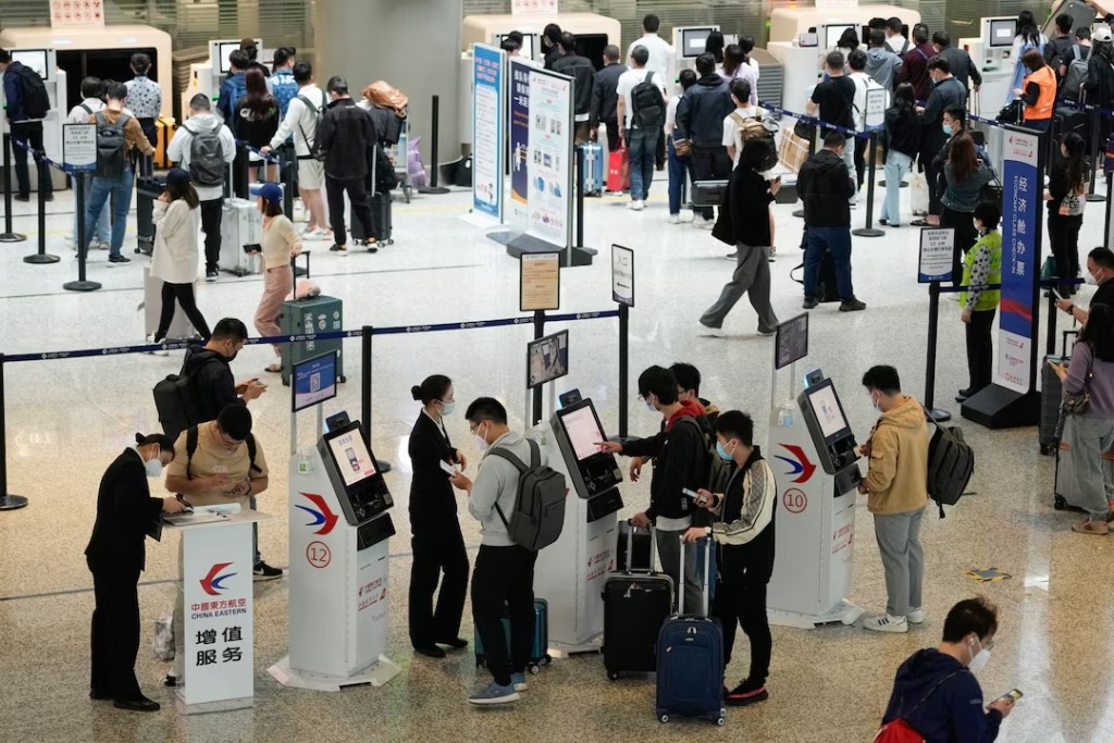 Travellers wait at check-in counters of Shanghai Hongqiao International Airport ahead of the five-day Labour Day holiday, in Shanghai, China, April 28, 2023. REUTERS/Aly Song