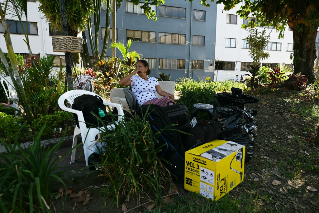 Photo by LUIS ACOSTA / AFP A woman surrounded by her belongings gestures near a collapsed building following an earthquake in Pereira, Colombia, on August 11, 2026.