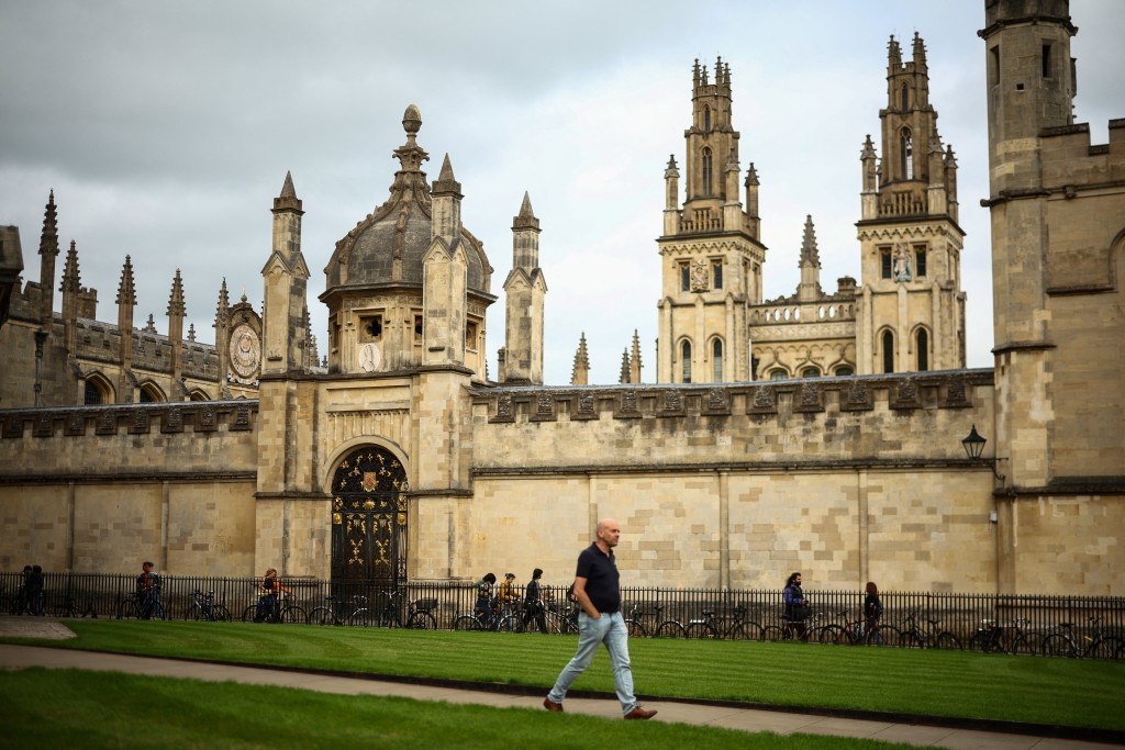 Photo by HENRY NICHOLLS / AFP  This photo taken on June 17, 2026 shows a man walking past the All Souls College Library at Oxford University in Oxford, central England.