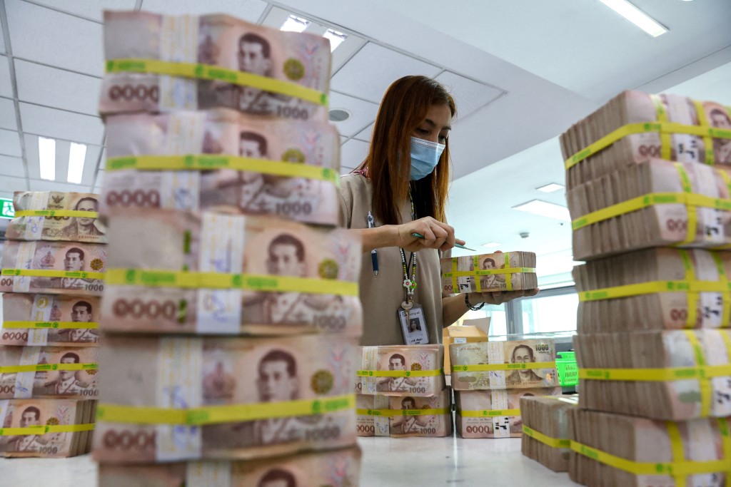  A bank employee gathers Thai baht notes at a Kasikornbank in Bangkok, Thailand, January 26, 2023. REUTERS
