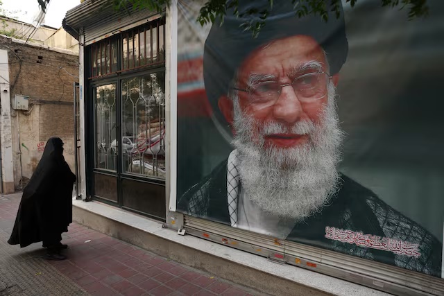 A woman walks past a banner with a picture of the late Iran's Supreme Leader Ayatollah Ali Khamenei, on a street in Tehran, Iran June 7, 2026. Majid Asgaripour/WANA (West Asia News Agency) via REUTERS/File Photo 