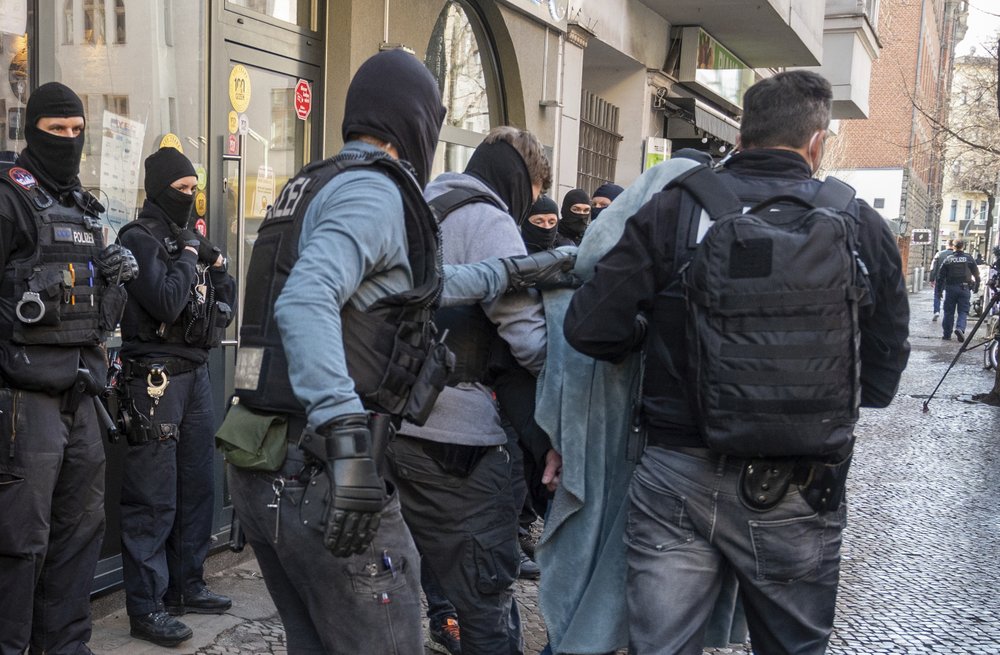 A man is led away by police during a raid in Berlin, Germany, Thursday, February 18, 2021. Police cracked down on clan crime in Berlin and the surrounding area with a major raid on Thursday morning. A man is led away by police during a raid in Berlin, Germany, Thursday, February 18, 2021. Police cracked down on clan crime in Berlin and the surrounding area with a major raid on Thursday morning.