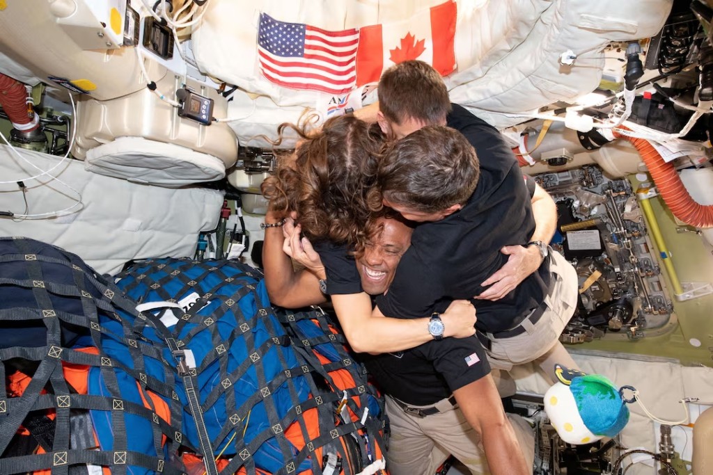 The NASA Artemis II crew, Mission Specialist Christina Koch, Mission Specialist Jeremy Hansen, Commander Reid Wiseman, and Pilot Victor Glover, embrace inside the Orion spacecraft on their way home following a flyby of the far side of the Moon on April 7, 2026. NASA/Handout via REUTERS 