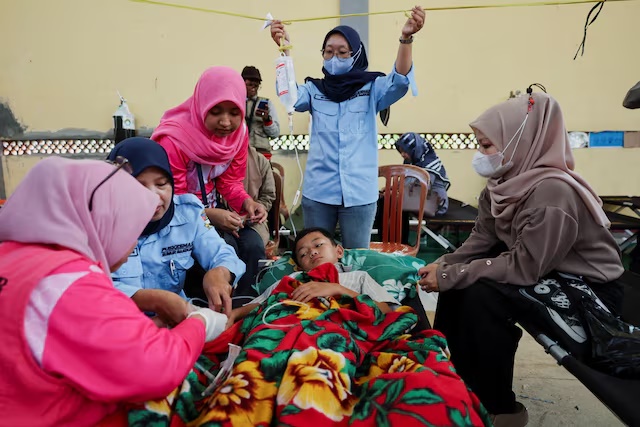 Muhammad Setiawan Pratama, 11, an elementary student receives treatment for food poisoning after eating government-sponsored free school meals, at a makeshift clinic inside a district's hall in Bandung, West Java province, Indonesia, September 25, 2025. REUTERS/Willy Kurniawan 