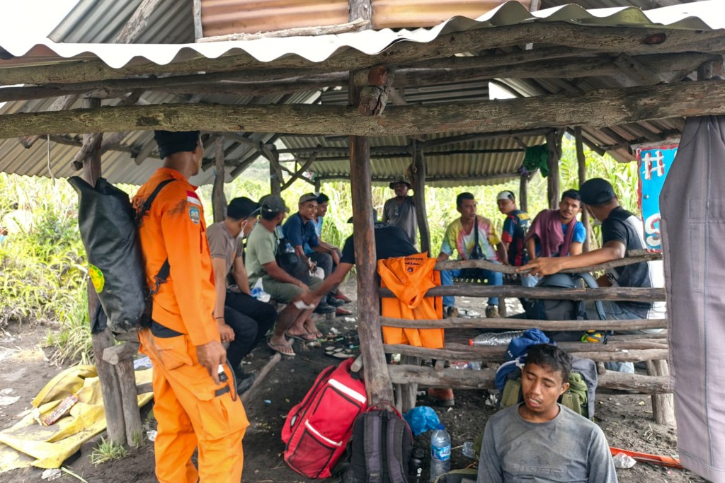 Photo by HANDOUT / NATIONAL SEARCH AND RESCUE AGENCY (BASARNAS) / AFP  A handout picture taken and released on May 8, 2026 by Indonesia's National Search and Rescue Agency (BASARNAS) shows rescue workers waiting in a shelter after the volcanic eruption of Mount Dukono in North Halmahera, North Maluku.