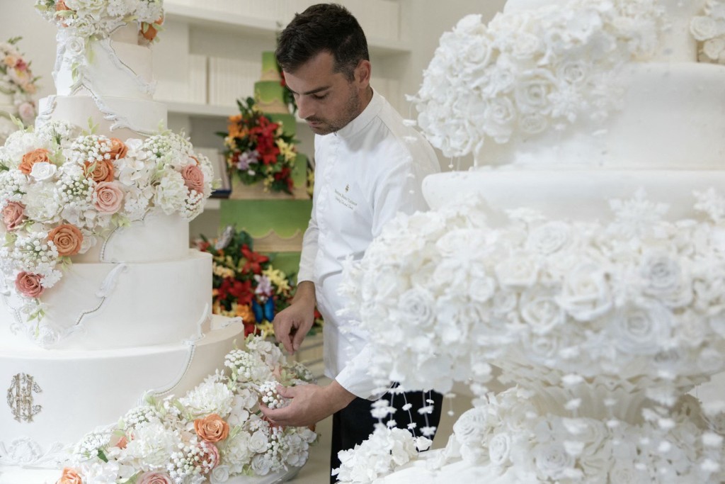 Photo by THOMAS SAMSON / AFP  French pastry chef Bastien Blanc-Tailleur decorates a wedding cake at his studio in Saint-Remy-les-Chevreuse, southwestern Paris on April 10, 2026.