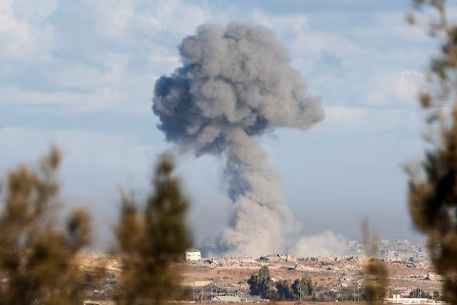 Smoke rises from an explosion in Gaza, as people attend a memorial to commemorate the two-year anniversary of the deadly October 7, 2023 attack on Israel by Hamas from Gaza, in Kibbutz Kfar Aza, as seen from southern Israel, October 7, 2025. REUTERS/Ronen Zvulun 