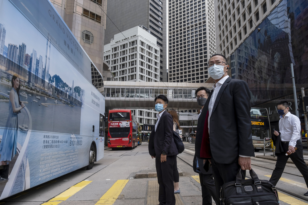 Commuters wait to cross a road in the Central district of Hong Kong. (Bloomberg) Commuters wait to cross a road in the Central district of Hong Kong. (Bloomberg)