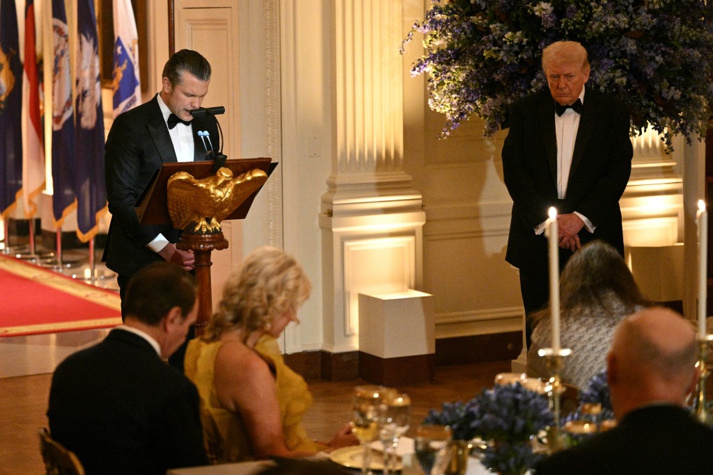 Photo by MANDEL NGAN / AFP  Defense Secretary Pete Hegseth (L) conducts a prayer as US President Donald Trump (R) listens during a dinner with state governors in the East Room of the White House in Washington, DC, on February 21, 2026.