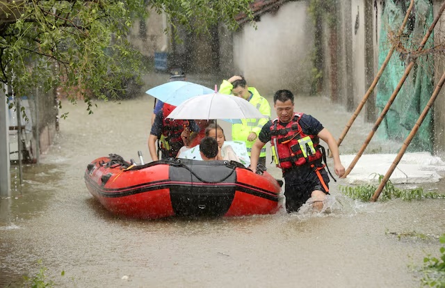 Rescue workers evacuate stranded villagers by lifeboat at a flooded village, following heavy rainfall brought by the remnants of Typhoon Dolphin, in Deqing county, Huzhou, Zhejiang province, China August 14, 2026. China Daily via REUTERS