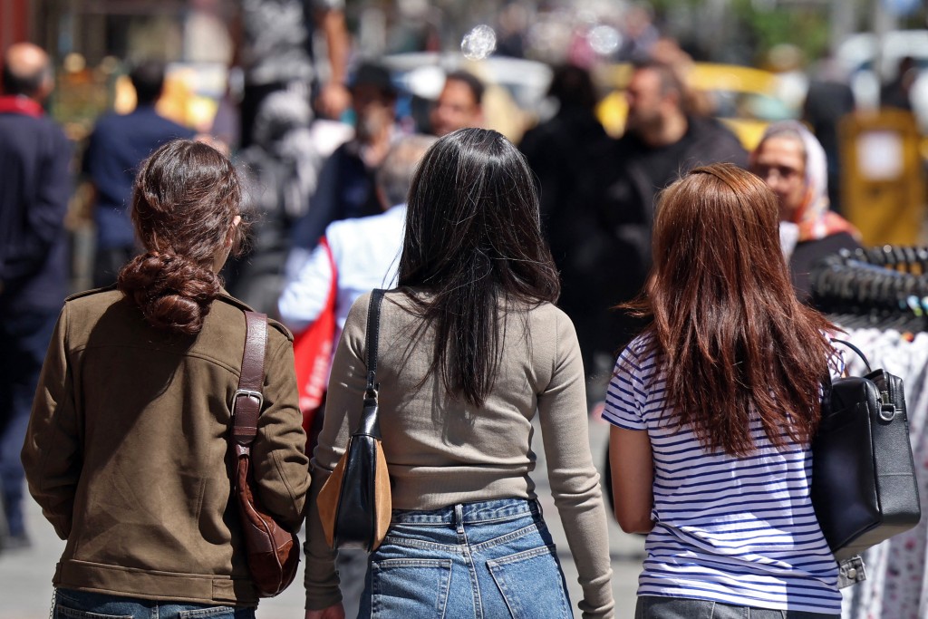 Iranian women walk along a busy street in Tehran on April 25, 2026. (Photo by AFP) 