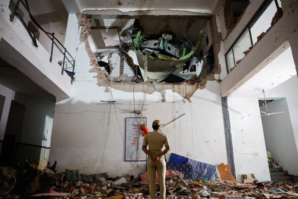  A police officer stands in front of the wreckage of an Air India aircraft, bound for London's Gatwick Airport, which crashed during take-off from an airport in Ahmedabad, India June 12, 2025. REUTERS/Adnan Abidi 
