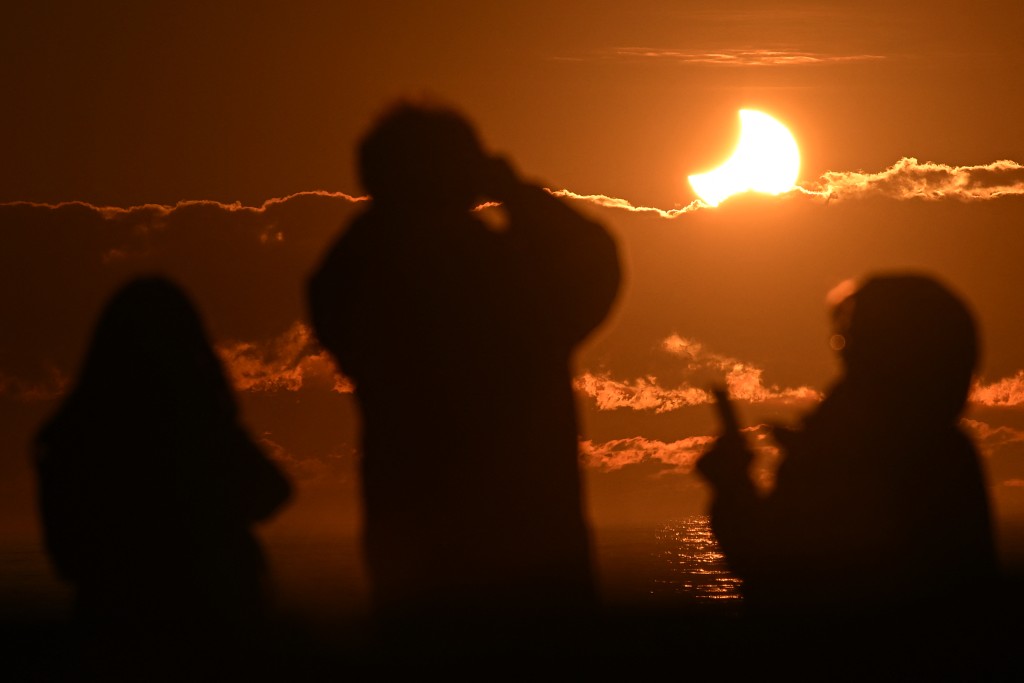 Photo by SANKA VIDANAGAMA / AFP People watch a partial solar eclipse at New Brighton, a coastal suburb of Christchurch, on September 22, 2025.