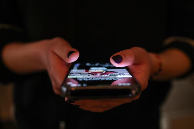 A girl checks social media posts on her phone in Athens, Greece, April 1, 2026. REUTERS/Louisa Gouliamaki/File Photo